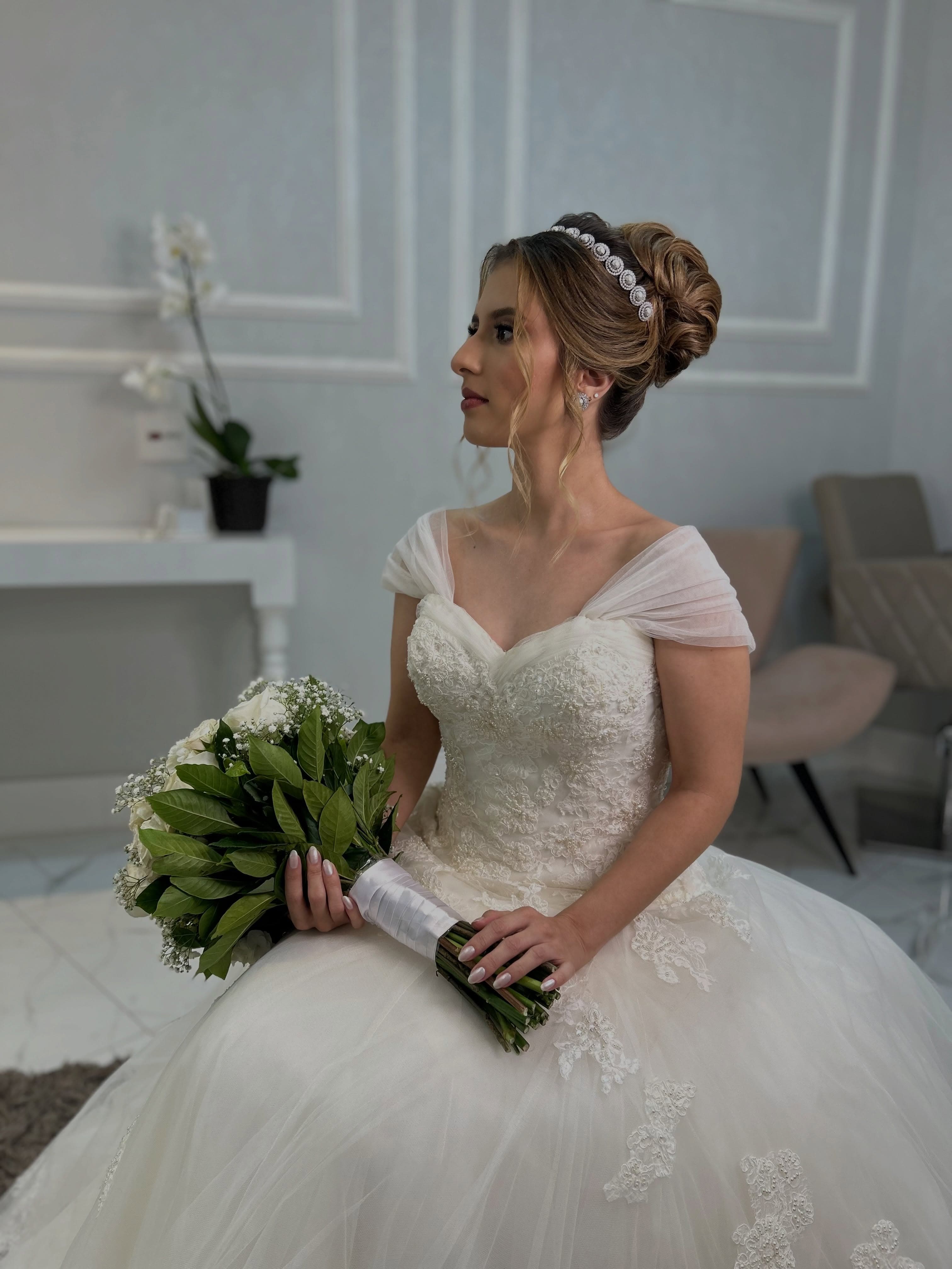 Noiva sentada de vestido de princesa e buquê