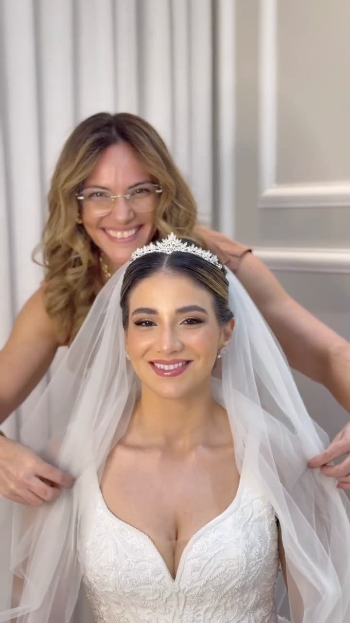Cabeleireira ajeitando o véu da noiva